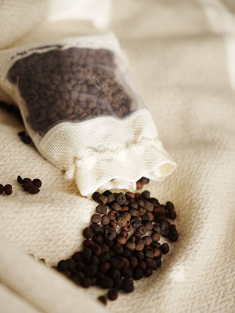 Coffee-ground pellets spilling out of a breathable fabric bag